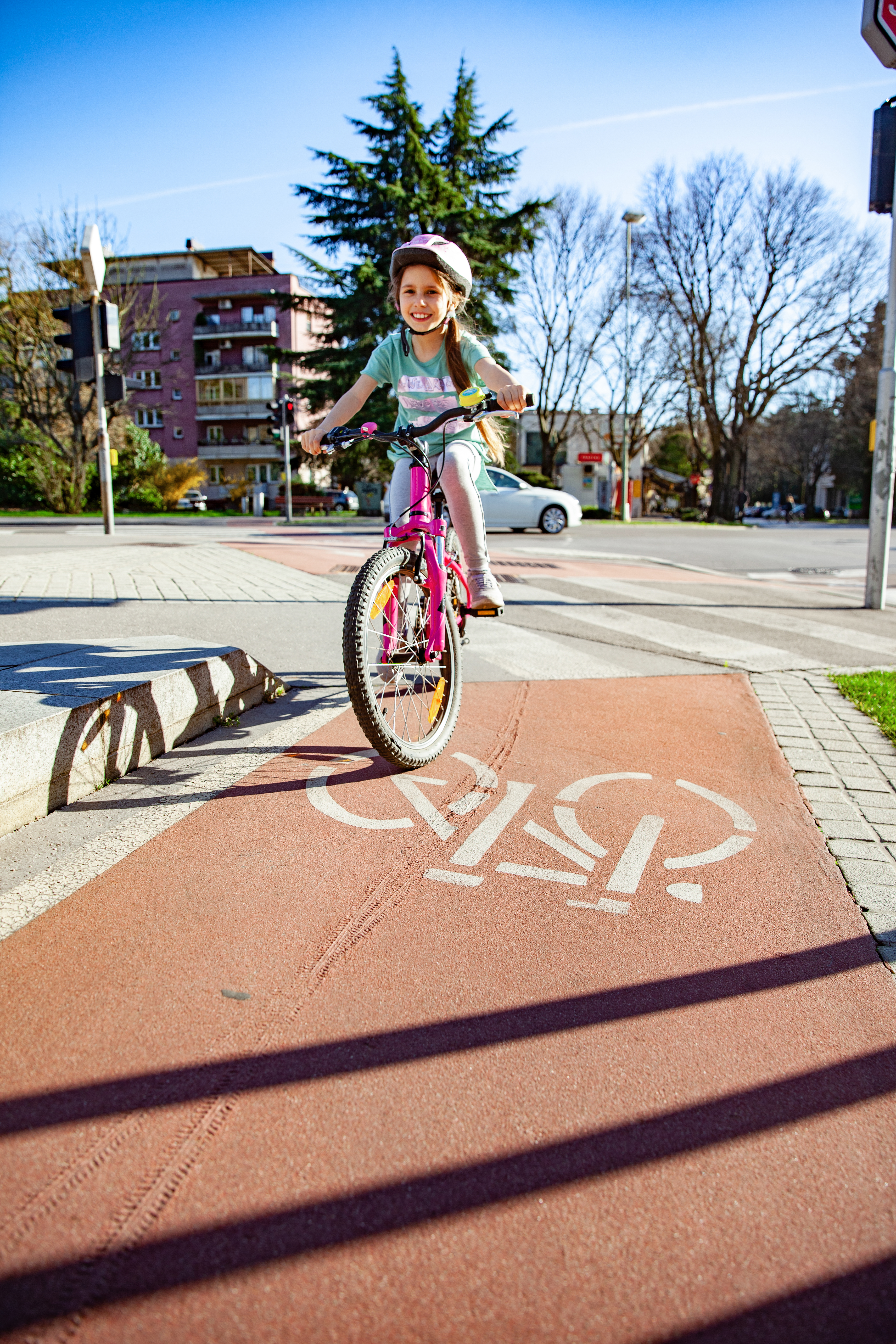 Ein Mädchen auf einem Kinderfahrrad fährt auf einem Radweg