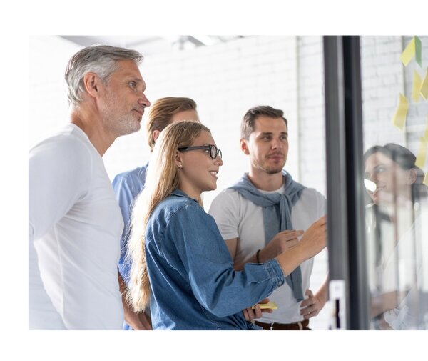 Team von vier Personen am Whiteboard plant